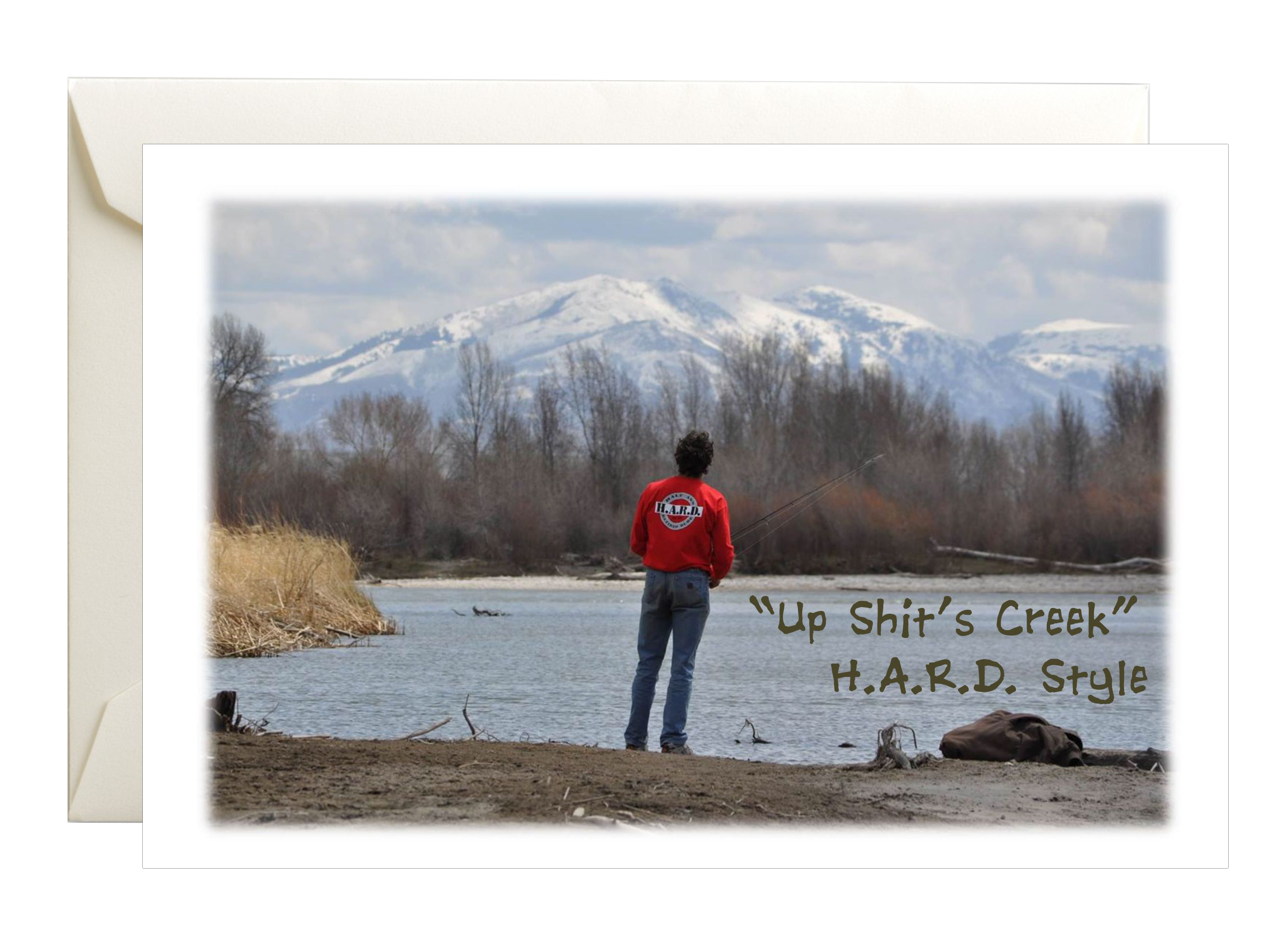 Image of guy fishing on a river wearing a HARD shirt with mountains in the back